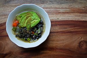 Black bean vegetable soup with avocado and cumin