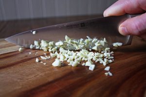 Garlic prep for black bean vegetable soup with avocado