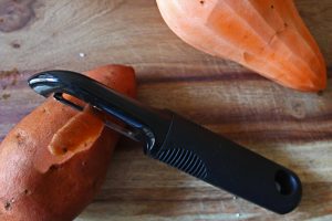 Peeling sweet potatoes for a sweet potato quinoa salad