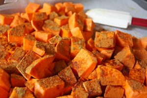 Sweet potatoes tossed with olive oil, cinnamon, cumin, cayenne, and salt