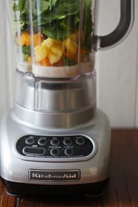 Ingredients for the tropical green smoothie bowl in the blender